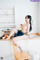 A naked woman sitting on a chair in a kitchen.