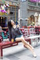 A woman sitting on a bench with a cup of coffee.