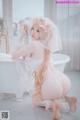 A woman in a wedding dress sitting in a bathtub.