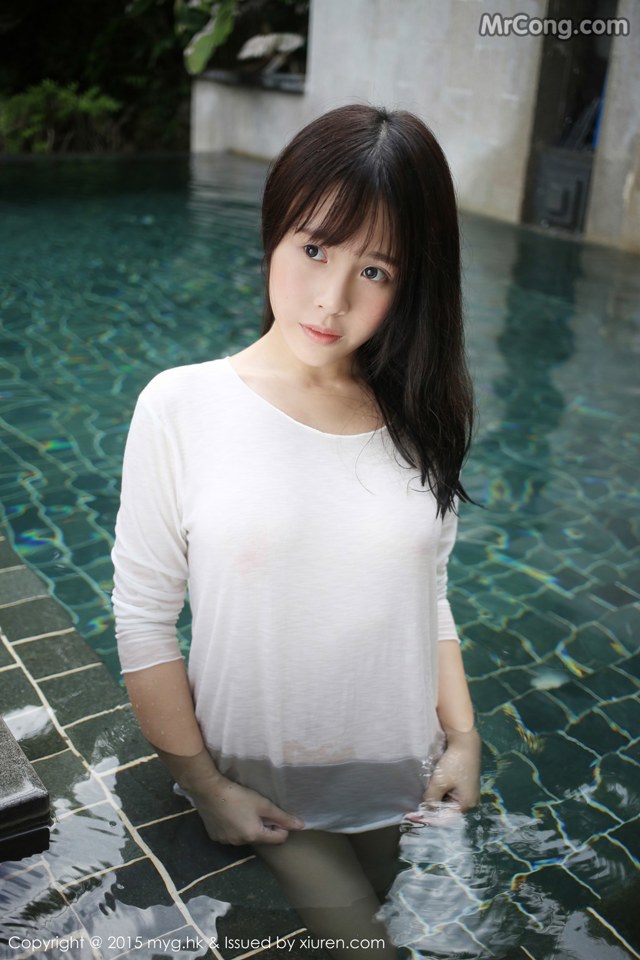 A woman in a white shirt standing in a pool.