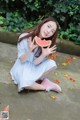 A woman sitting on the ground eating a slice of watermelon.