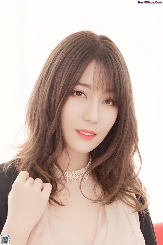 A woman with long brown hair wearing a black jacket.